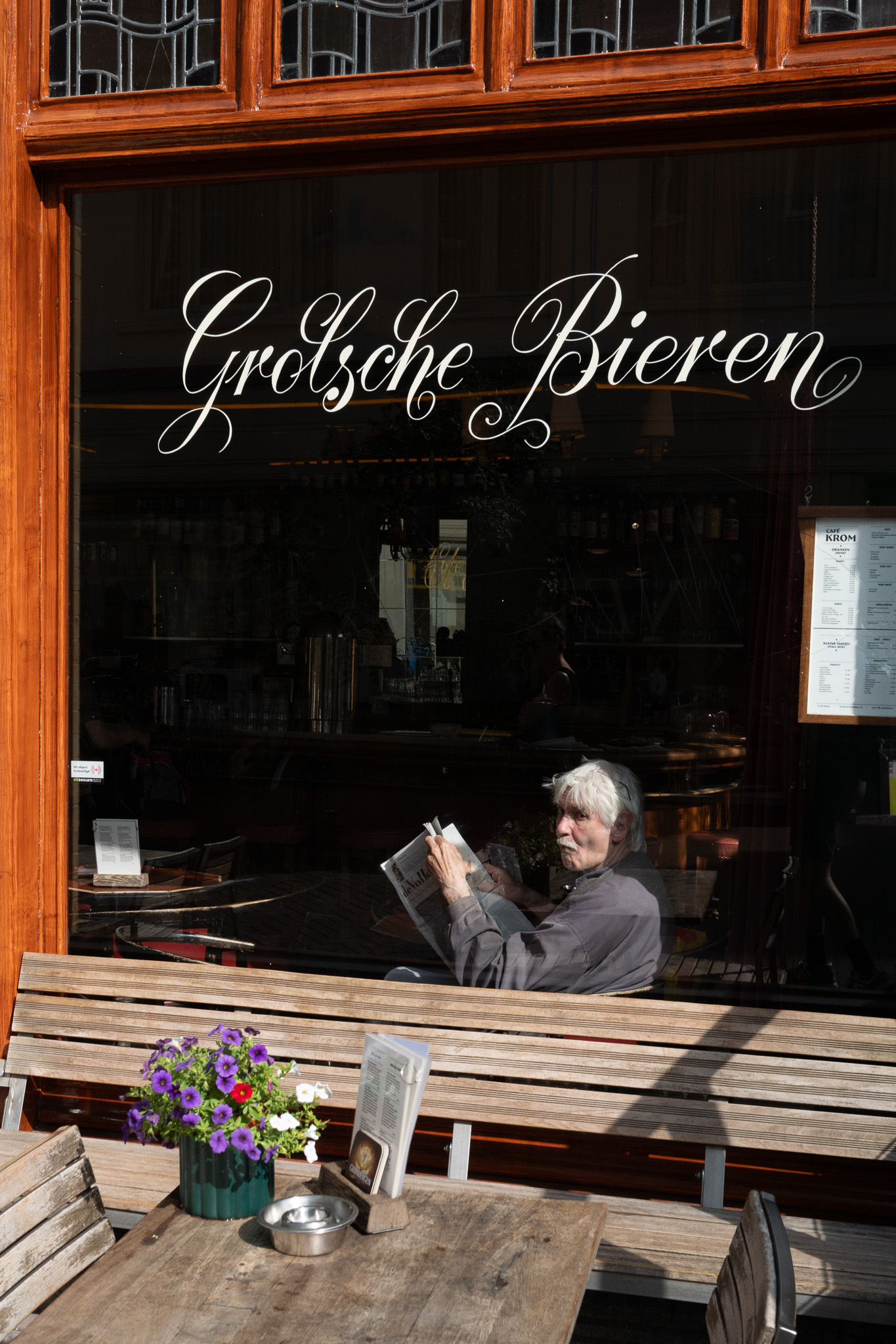 A man reading behind a cafe window